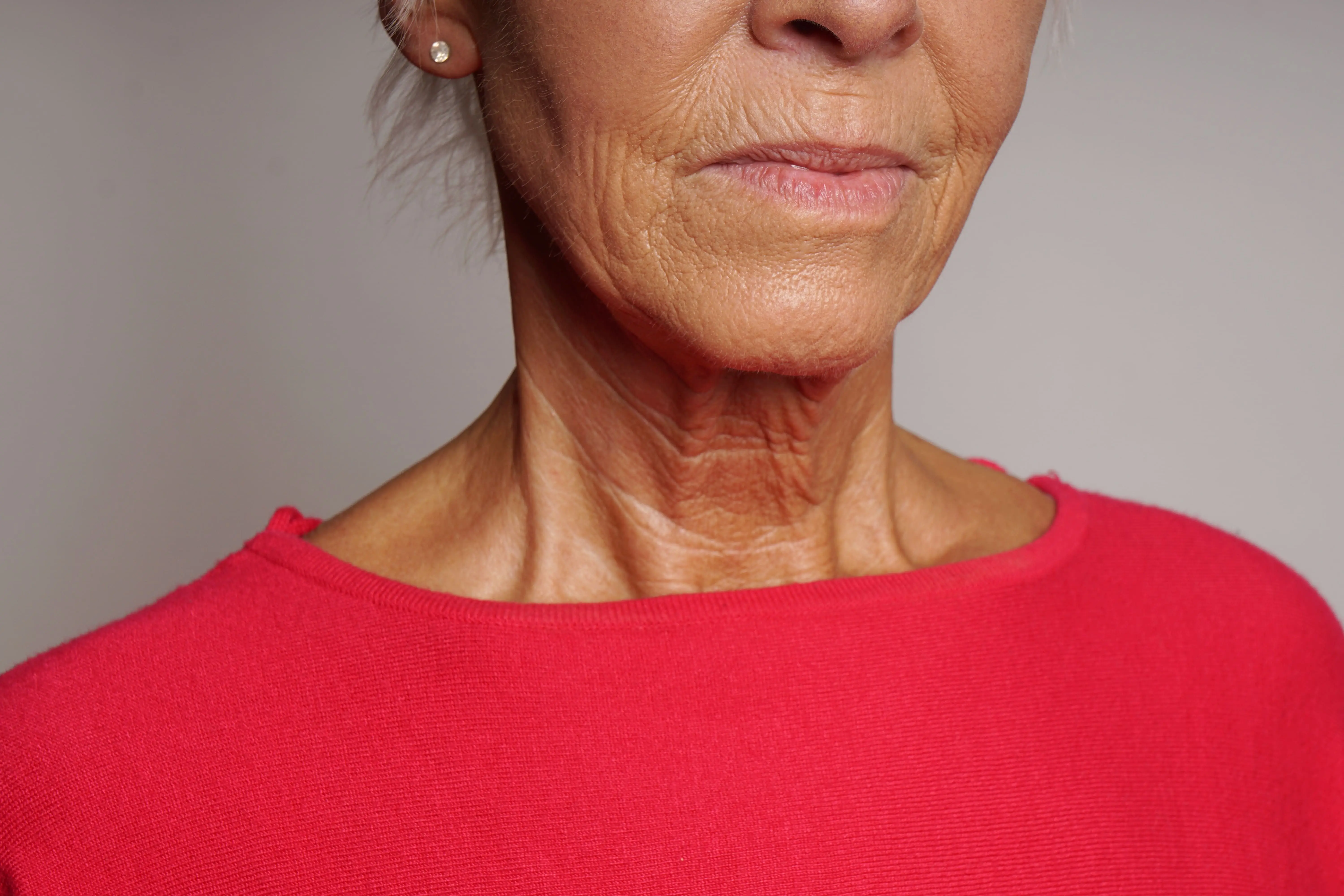 midsection-senior-woman-against-white-wall-1
