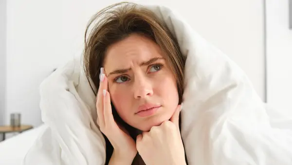 femme avec visage gonfl&eacute; le matin